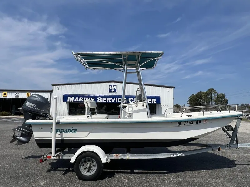 Slide: The Image of 2004 Sundance F17 boat on trailer at Marine Service Center, clear sky background. - 4
