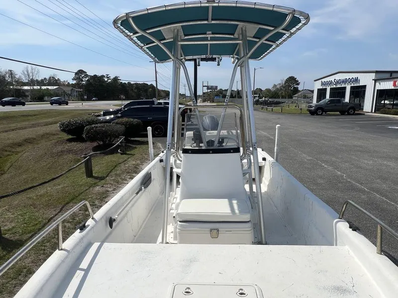 Slide: The Image of 2004 Sundance F17 boat with T-top, parked near a showroom on a sunny day. - 7