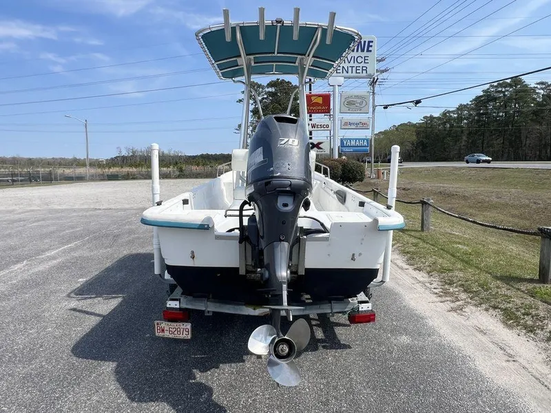 Slide: The Image of 2004 Sundance F17 boat with outboard motor parked near service center. - 9