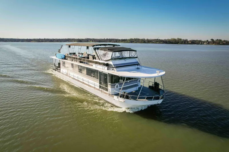 Slide: The Image of 1989 Sumerset houseboat cruising on a calm lake under a clear blue sky. - 12