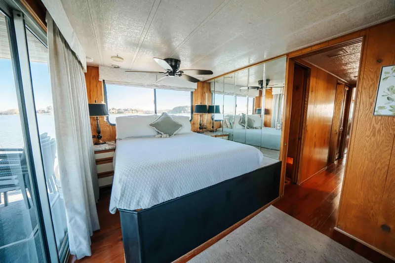 Slide: The Image of 1989 Sumerset houseboat bedroom with large bed, mirrored closet, and lake view. - 15