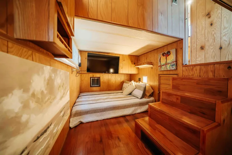 Slide: The Image of Cozy 1989 Sumerset houseboat interior with wooden decor, bed, and TV. - 19