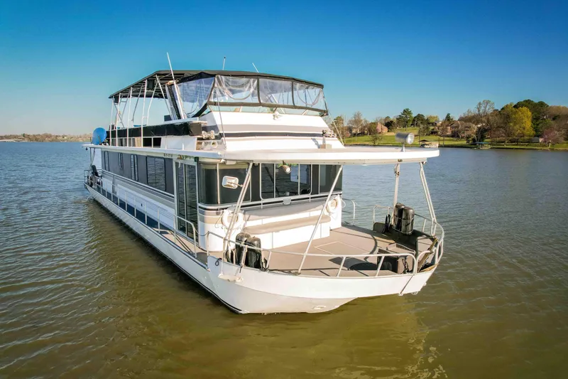 Slide: The Image of 1989 Sumerset houseboat on a serene lake with clear blue skies. - 2