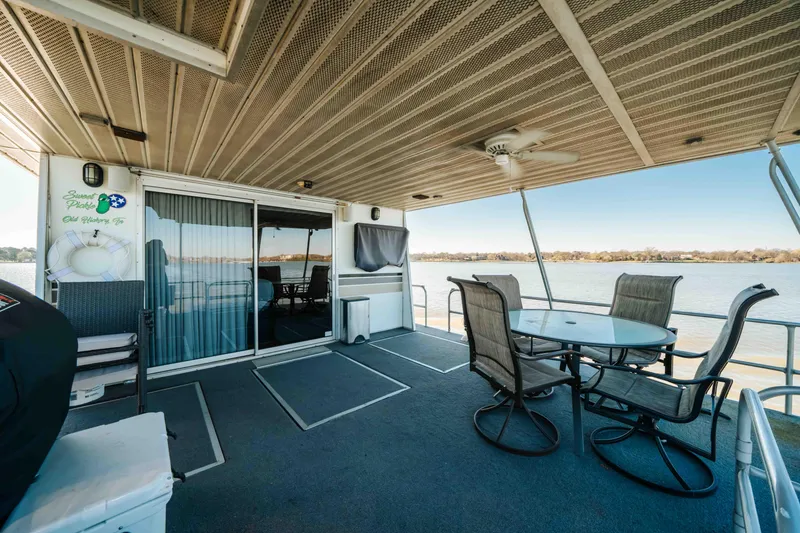 Slide: The Image of 1989 Sumerset houseboat deck with outdoor seating, ceiling fan, and scenic water view. - 22