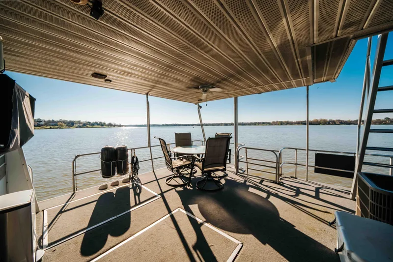 Slide: The Image of 1989 Sumerset houseboat deck with chairs, table, and scenic lake view. - 26