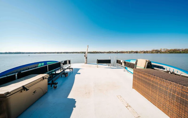 Slide: The Image of 1989 Sumerset houseboat deck with seating, overlooking calm waters under a clear blue sky. - 28