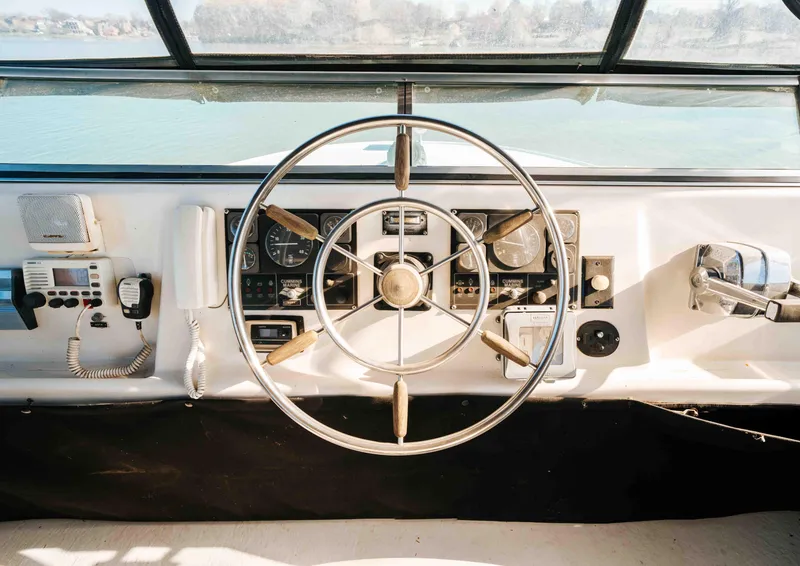 Slide: The Image of 1989 Sumerset houseboat helm with steering wheel, controls, and communication devices. - 30
