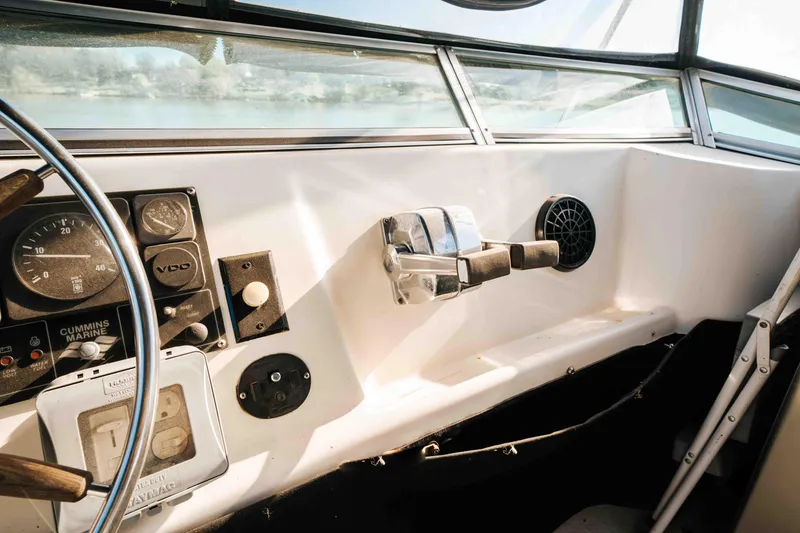 Slide: The Image of 1989 Sumerset houseboat helm with steering wheel, controls, and gauges, showcasing vintage nautical design. - 31