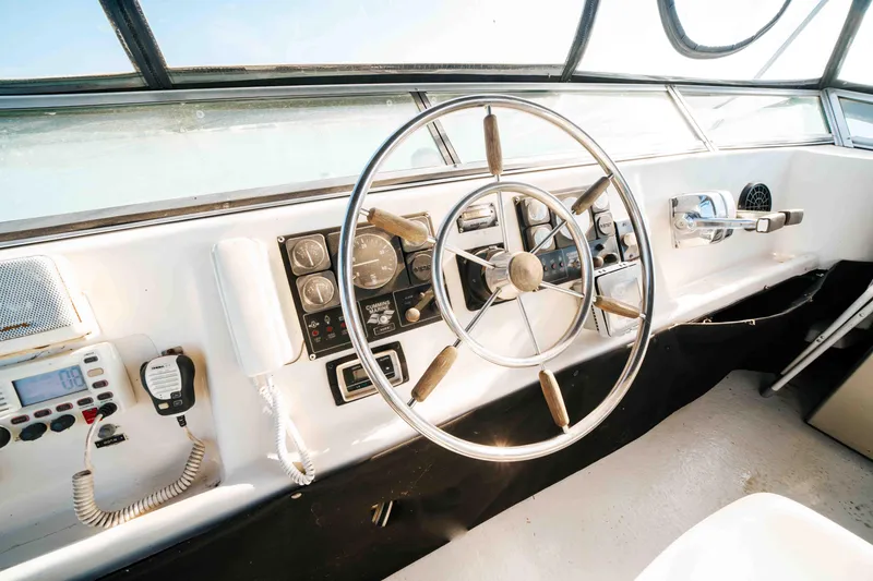 Slide: The Image of 1989 Sumerset houseboat helm with steering wheel and control panel. - 34