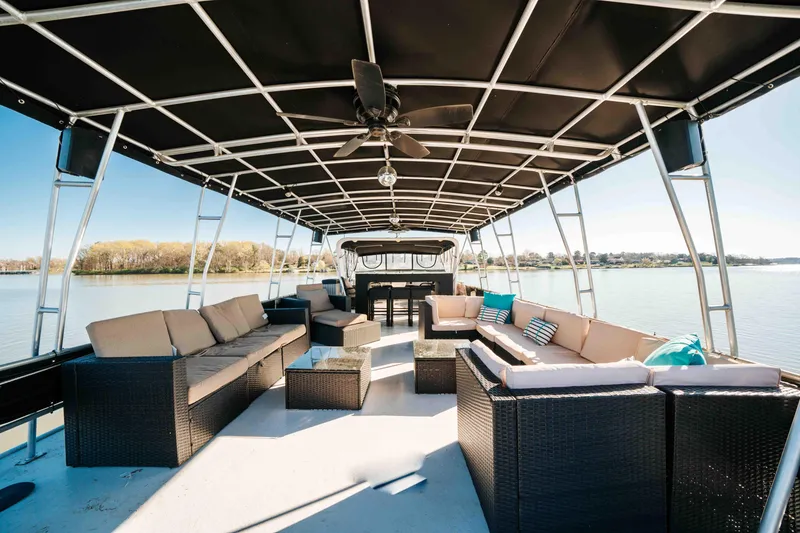 Slide: The Image of 1989 Sumerset houseboat with spacious outdoor seating and canopy on a serene lake. - 37