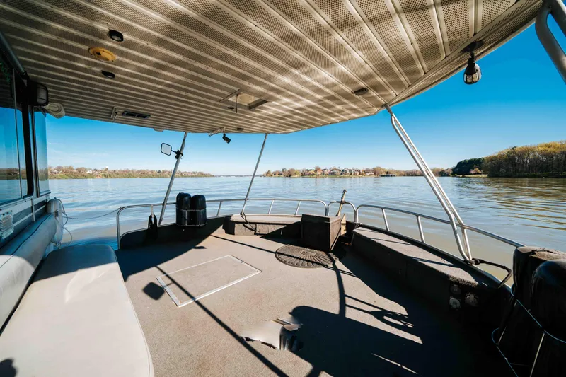 Slide: The Image of 1989 Sumerset houseboat deck with scenic lake view under clear blue sky. - 40