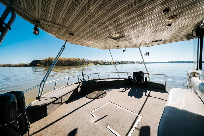 Slide: The Image of 1989 Sumerset houseboat deck with scenic lake view and clear blue sky. - 41