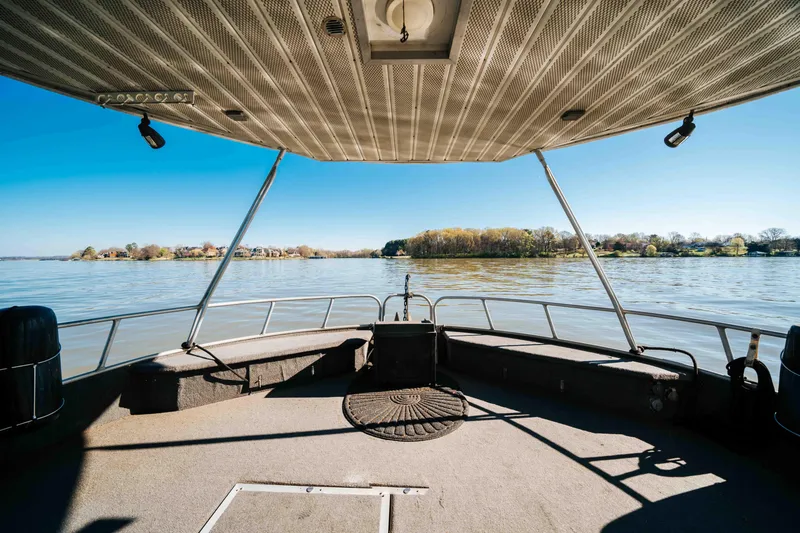 Slide: The Image of 1989 Sumerset houseboat deck with scenic lake view under clear blue sky. - 42