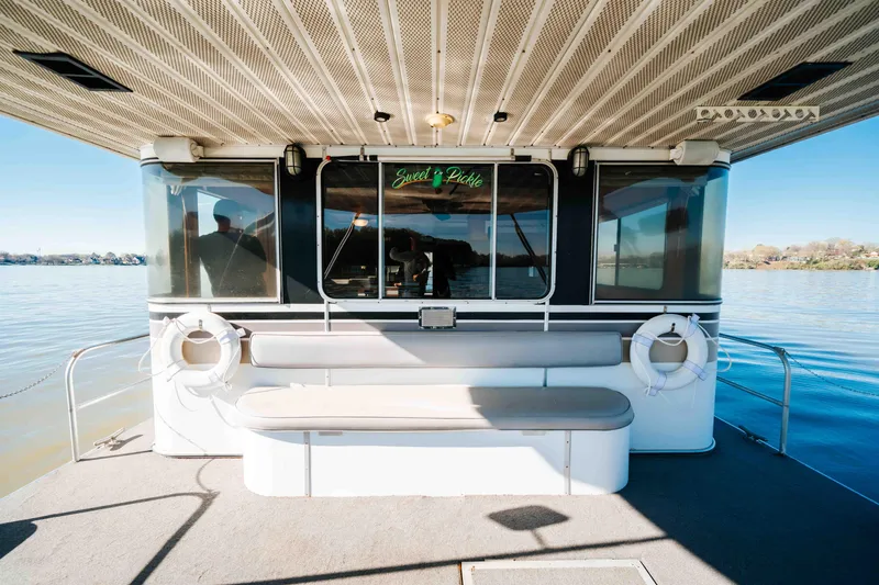 Slide: The Image of 1989 Sumerset houseboat with seating area and life rings on a calm lake. - 43