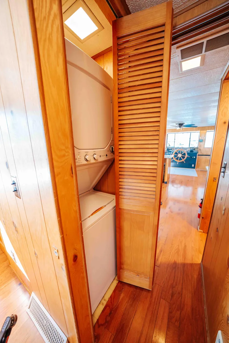 Slide: The Image of 1989 Sumerset houseboat interior with stacked washer and dryer in wooden closet. - 46