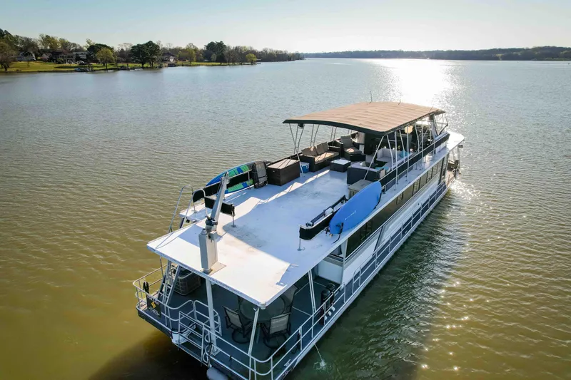 Slide: The Image of 1989 Sumerset houseboat cruising on a serene lake under clear skies. - 6