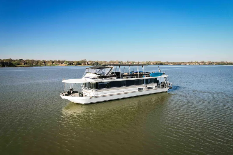 Slide: The Image of 1989 Sumerset houseboat cruising on a calm lake under a clear blue sky. - 8