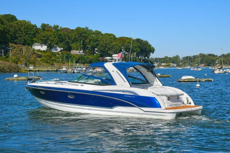 Slide: The Image of 2010 Formula 330 SS Super Sport boat cruising on a scenic lake. - 1