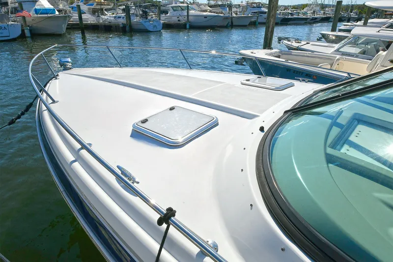 Slide: The Image of 2010 Formula 350 SS boat docked in a marina, showcasing sleek design and spacious deck. - 46