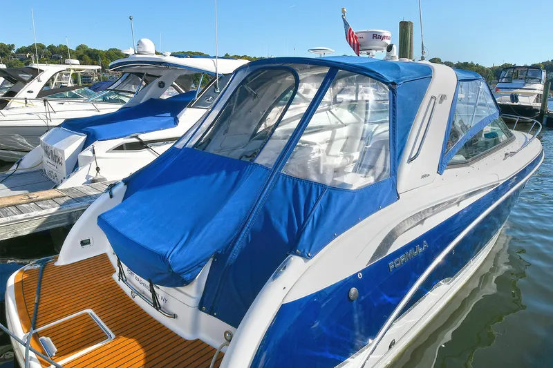 Slide: The Image of 2010 Formula 350 SS boat with blue cover docked at marina. - 7