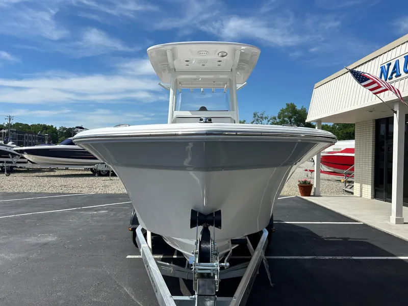Slide: The Image of 2025 Sea Fox 228 Commander boat on trailer, parked outside dealership under blue sky. - 2