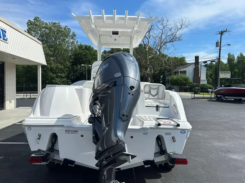 Slide: The Image of 2025 Sea Fox 228 Commander boat with outboard motor, parked outdoors on a sunny day. - 5