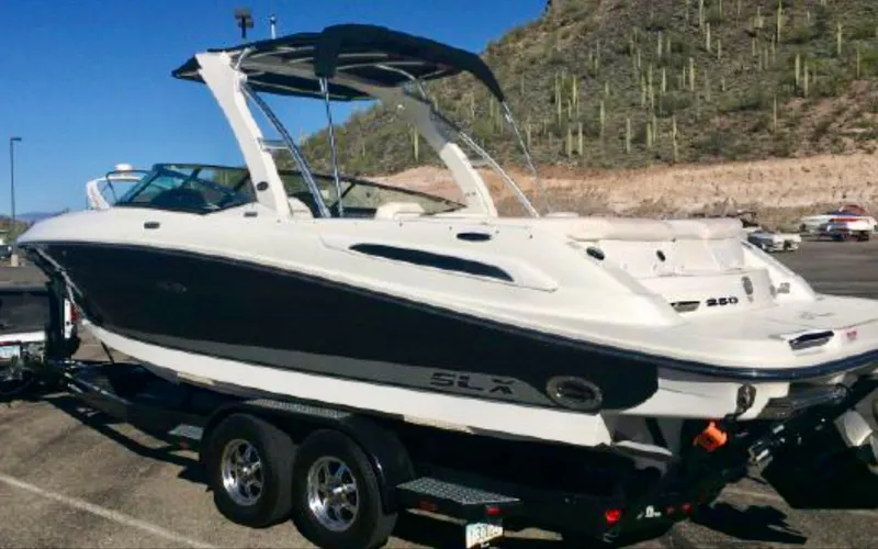 Slide: The Image of 2010 Sea Ray 250 SLX boat on trailer, parked in a scenic desert area. - 31