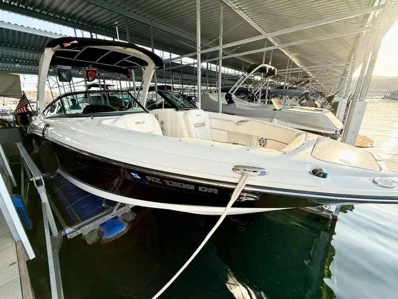 Slide: The Image of 2010 Sea Ray 250 SLX boat docked in a marina under a covered structure. - 34
