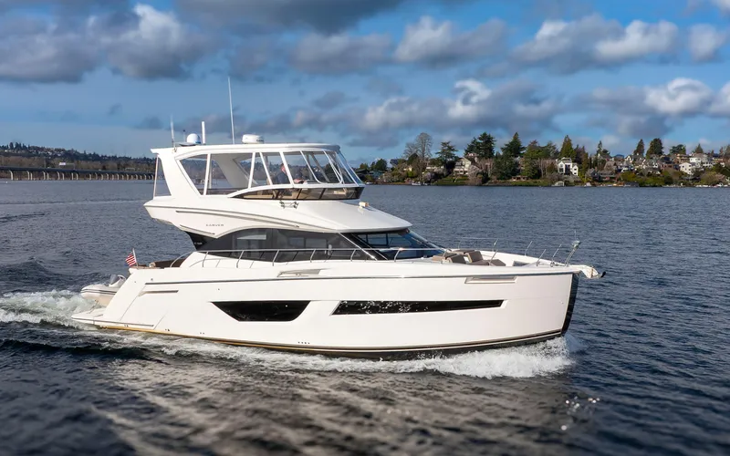 Slide: The Image of 2019 Carver C52 Command Bridge yacht cruising on a scenic waterway. - 0