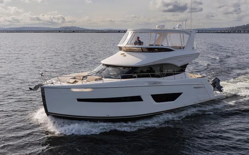 Slide: The Image of 2019 Carver C52 Command Bridge yacht cruising on open water. - 1