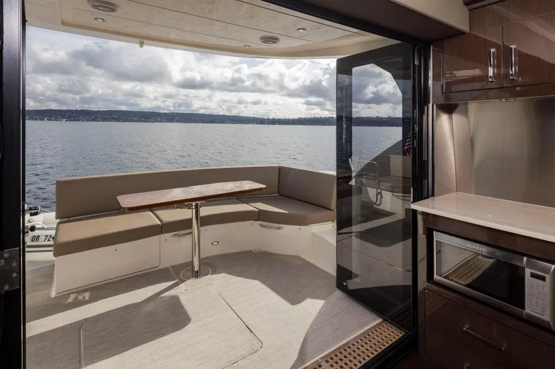 Slide: The Image of 2019 Carver C52 Command Bridge yacht interior with seating and ocean view. - 12