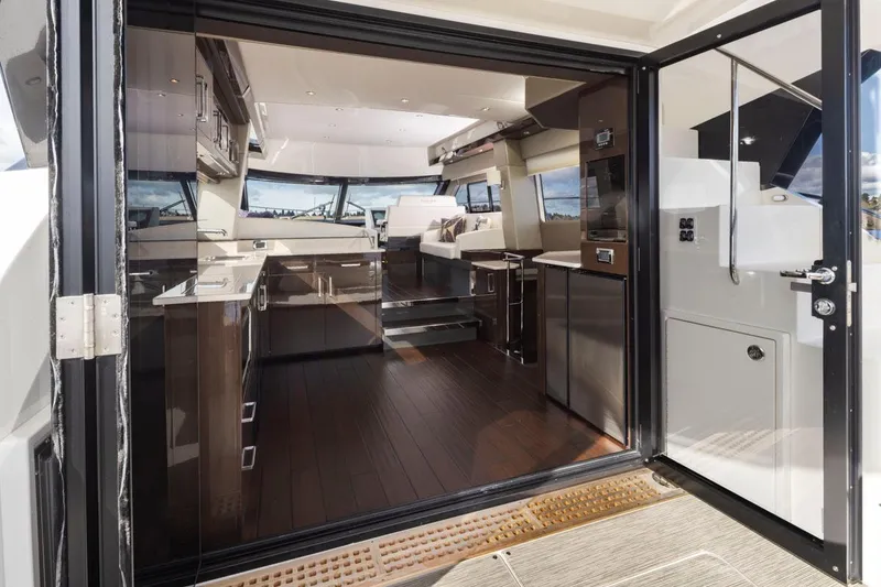 Slide: The Image of Luxurious interior of 2019 Carver C52 Command Bridge yacht with modern kitchen and seating area. - 15