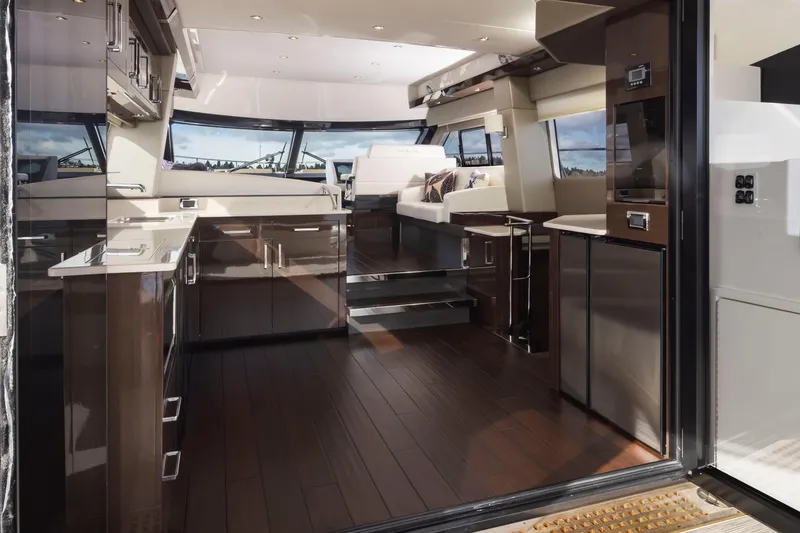 Slide: The Image of Luxurious interior of 2019 Carver C52 Command Bridge yacht with modern kitchen and seating area. - 16
