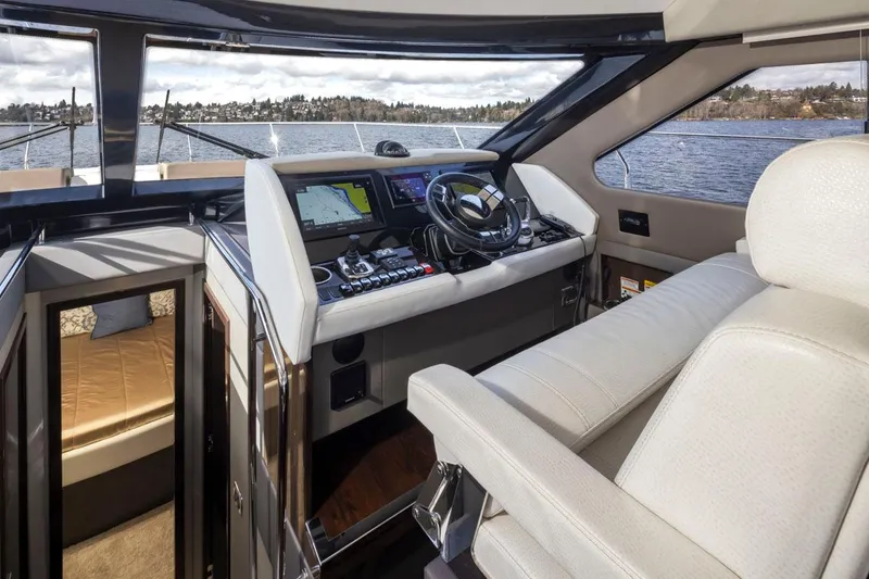 Slide: The Image of 2019 Carver C52 Command Bridge interior with helm, navigation screens, and luxurious seating. - 24