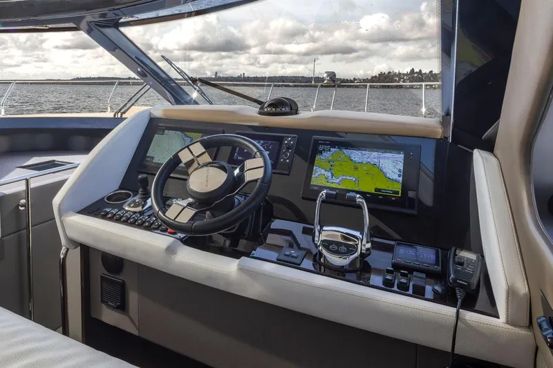 Slide: The Image of 2019 Carver C52 Command Bridge helm with navigation screens and steering wheel. - 26