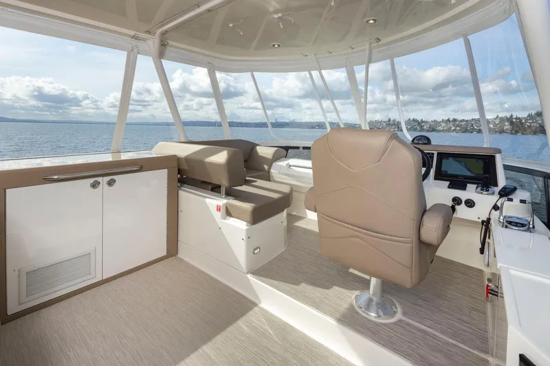 Slide: The Image of 2019 Carver C52 Command Bridge interior with helm, seating, and panoramic ocean view. - 41