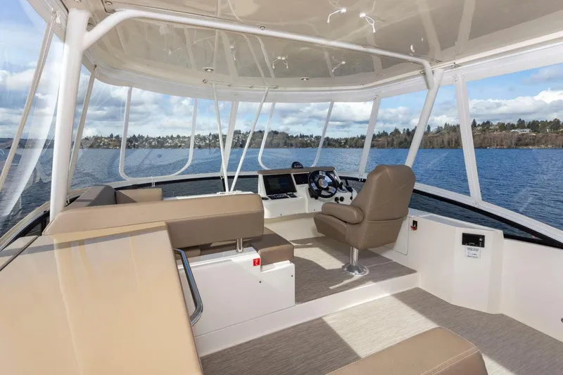 Slide: The Image of 2019 Carver C52 Command Bridge interior with beige seating and panoramic water views. - 43