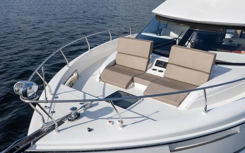 Slide: The Image of 2019 Carver C52 Command Bridge yacht with sun loungers on deck, cruising on calm waters. - 5