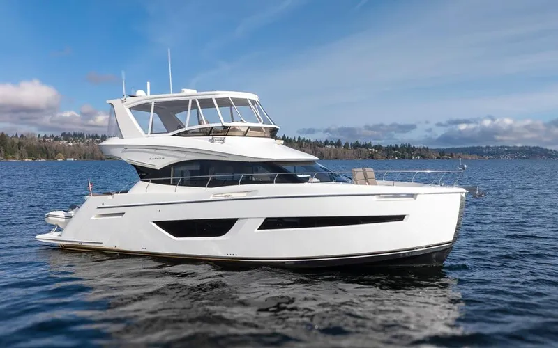 Slide: The Image of 2019 Carver C52 Command Bridge yacht cruising on a serene lake. - 6