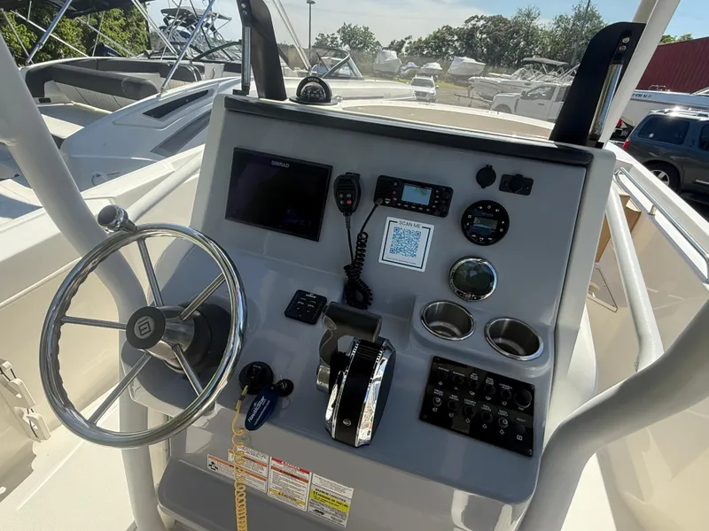 Slide: The Image of 2022 Trophy T24CC boat dashboard with steering wheel, controls, and navigation instruments. - 11