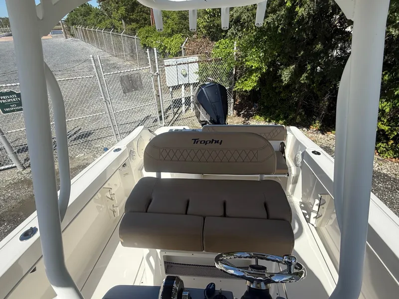 Slide: The Image of 2022 Trophy T24CC boat interior with beige seating and steering wheel. - 13