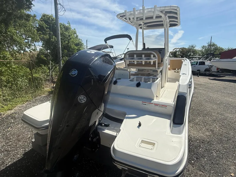 Slide: The Image of 2022 Trophy T24CC boat with outboard motor, parked outdoors on a sunny day. - 3