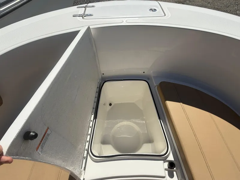 Slide: The Image of 2022 Trophy T24CC boat with open storage compartment and cushioned seating. - 8