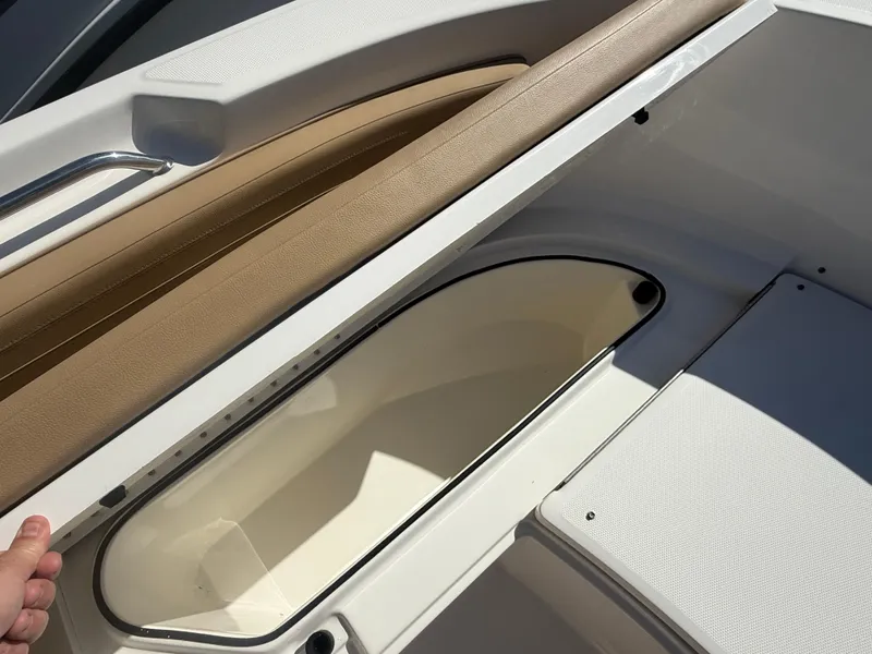 Slide: The Image of 2022 Trophy T24CC boat storage compartment with beige seating and white interior. - 9