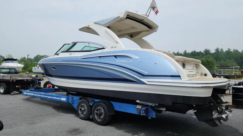 Slide: The Image of 2018 Formula 350 CBR boat on trailer, blue and white design, parked outdoors. - 2
