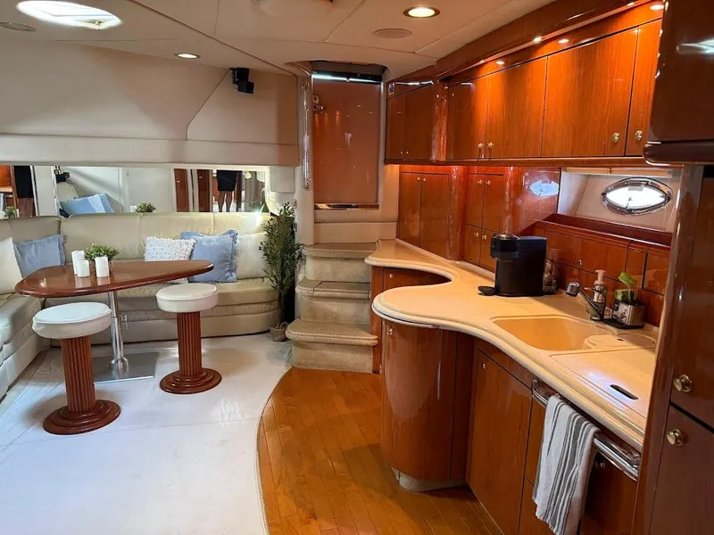 Slide: The Image of Luxurious interior of 2000 Sea Ray 510 Sundancer yacht with elegant wood finishes and cozy seating. - 21