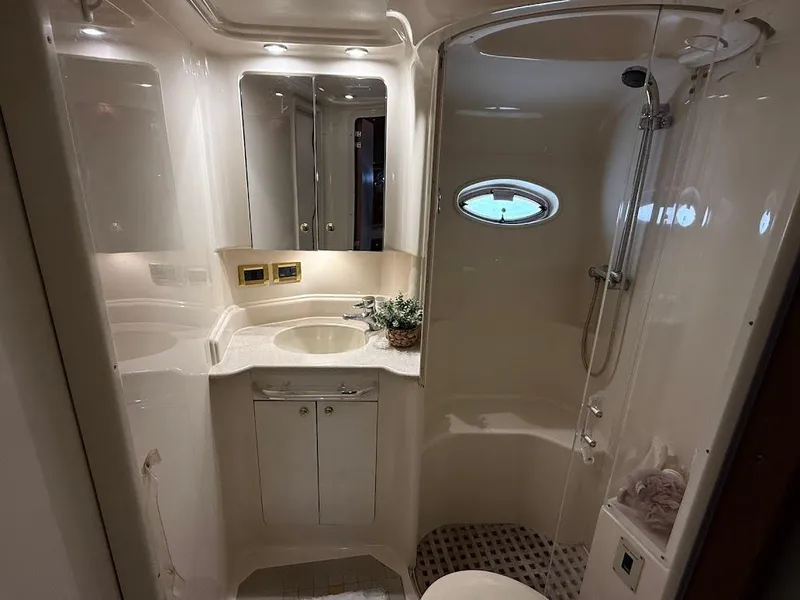 Slide: The Image of Luxurious bathroom in 2000 Sea Ray 510 Sundancer yacht, featuring elegant fixtures and a porthole window. - 34