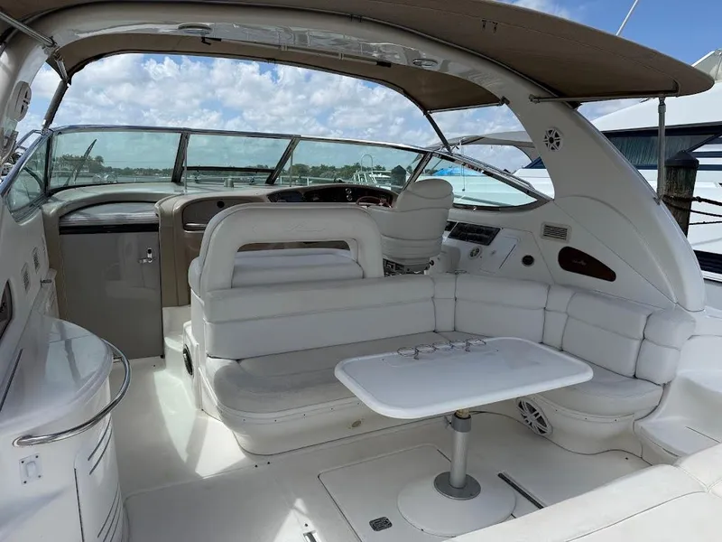 Slide: The Image of 2000 Sea Ray 510 Sundancer yacht interior with white seating and table, under a canopy. - 5