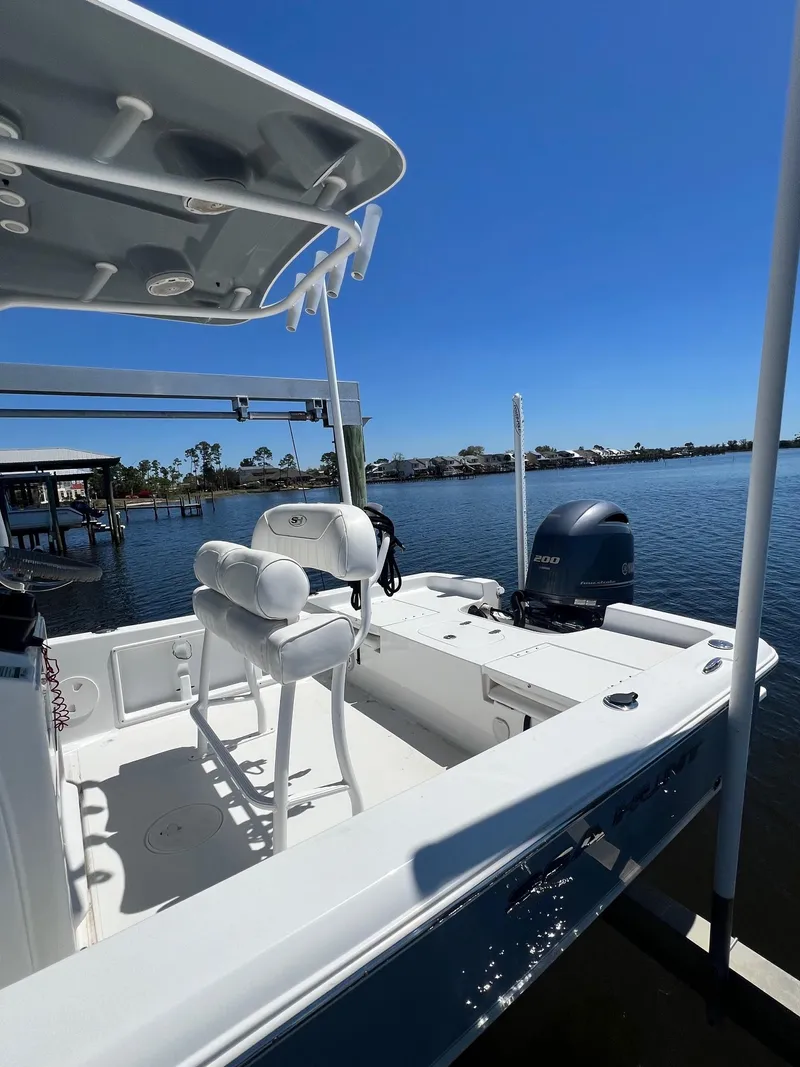 Slide: The Image of 2015 Sea Hunt BX 22 BR boat docked on a sunny day by the water. - 1
