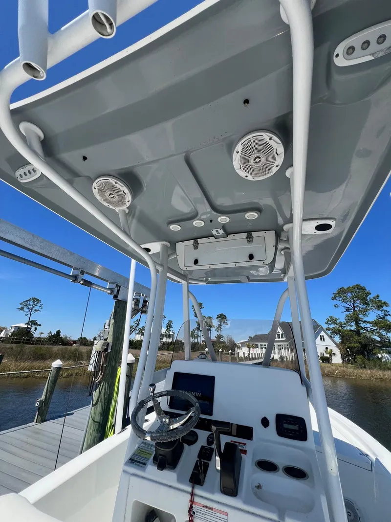 Slide: The Image of 2015 Sea Hunt BX 22 BR boat console with steering wheel and electronics under a blue sky. - 10